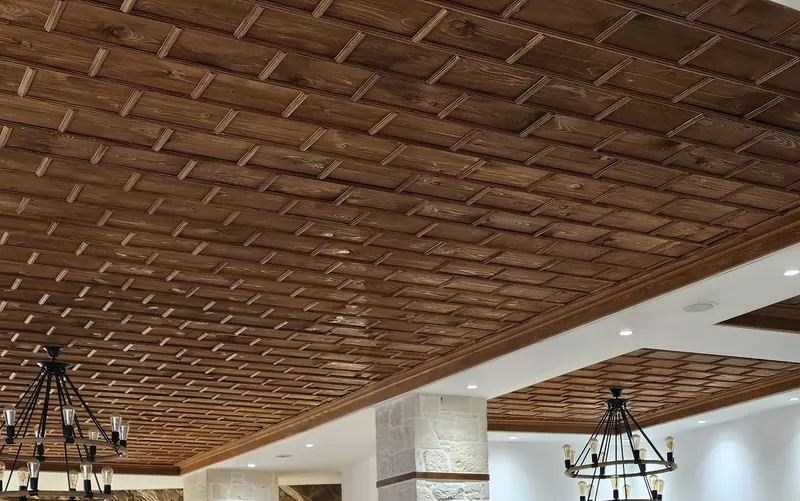 The dining room with its wooden ceiling, iron chandeliers and stone columns