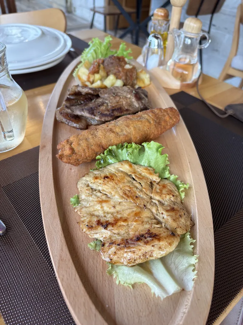 A long platter of grilled chicken fillet, meat and salad